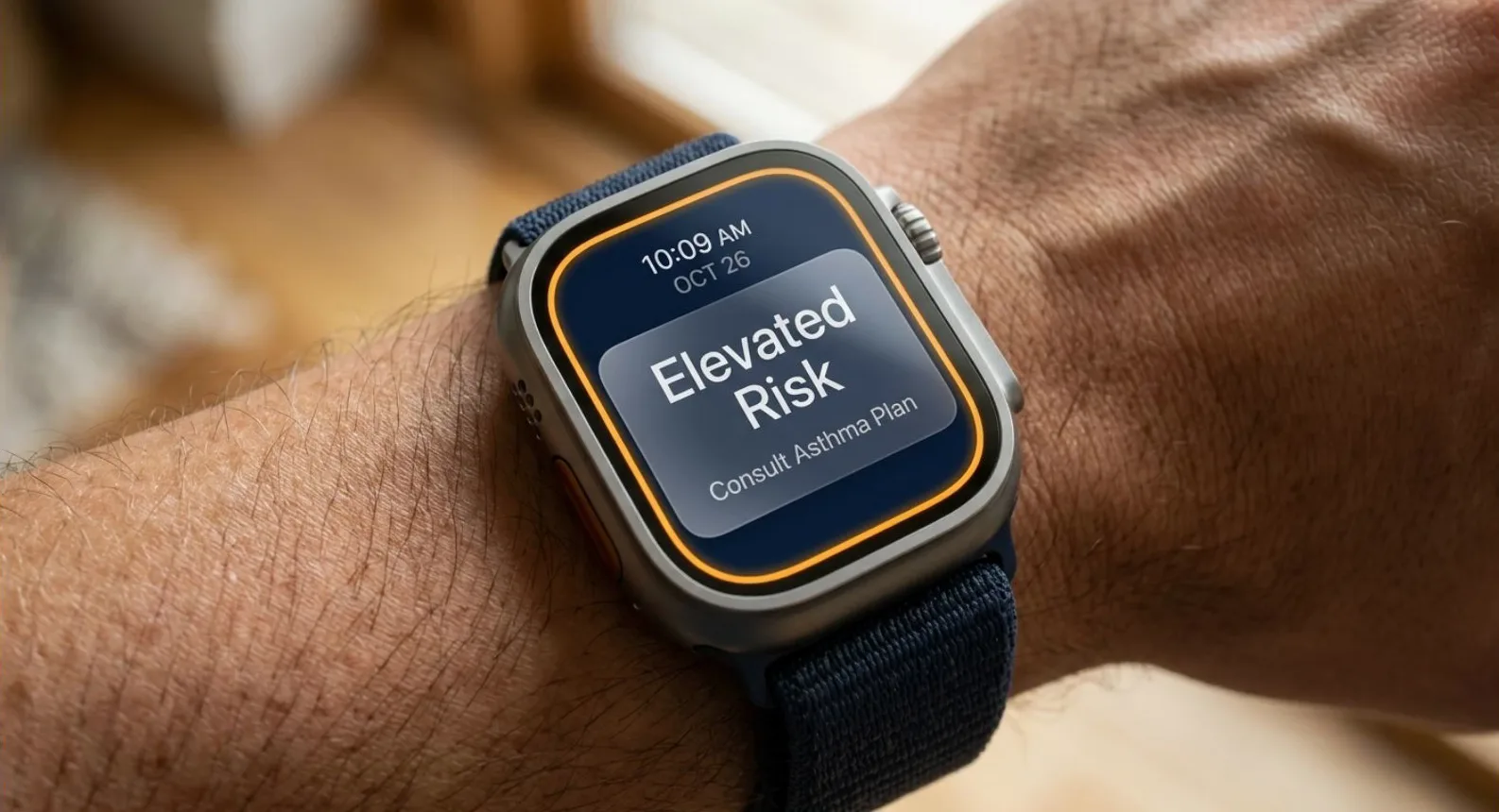 A smartwatch on a person's wrist, against a blurred warm indoor background. The screen shows a dark face ringed in orange, carrying a card that reads 'Elevated Risk' with 'Consult Asthma Plan' under it. The time reads 10:09 AM. The band is navy blue.